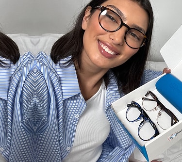 Woman unboxing prescription glasses from GlassesUSA with free shipping, online eyewear retailer packaging