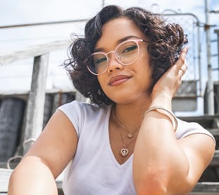 Woman wearing stylish prescription glasses from GlassesUSA online eyewear collection, affordable frames with free shipping