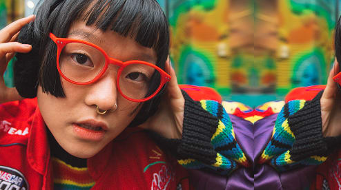 Woman wearing red prescription eyeglasses from GlassesUSA eyewear collection, affordable frames with free shipping